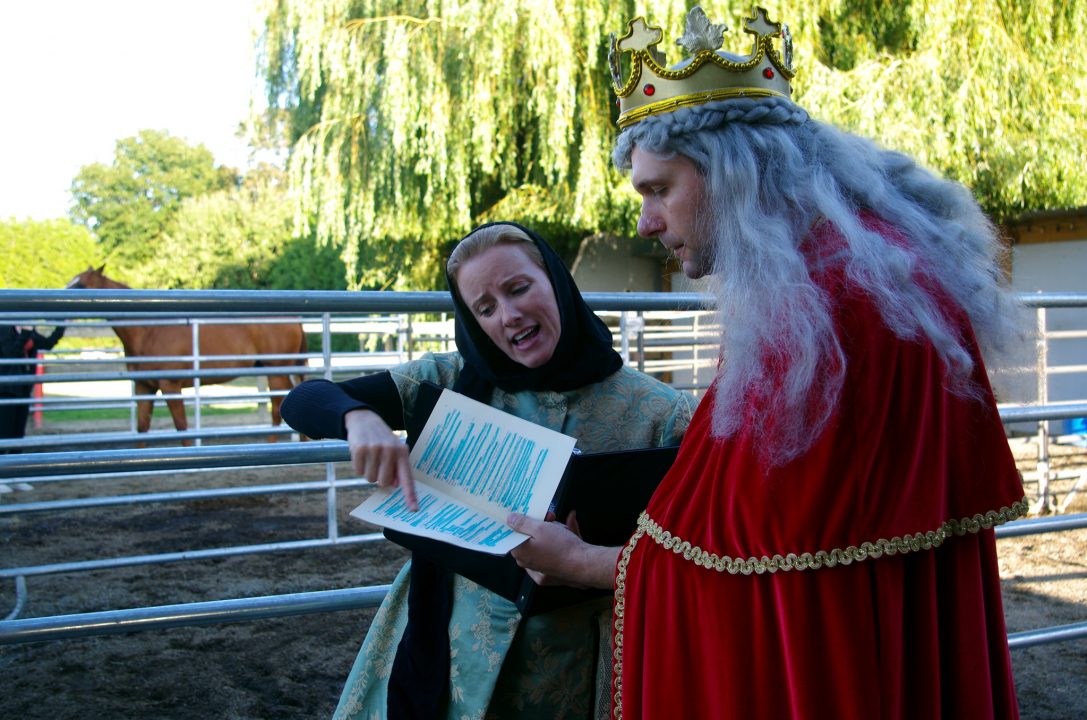 Amateuar actor explains script to Hollywood Actor playing King Lear with barn setting in the background